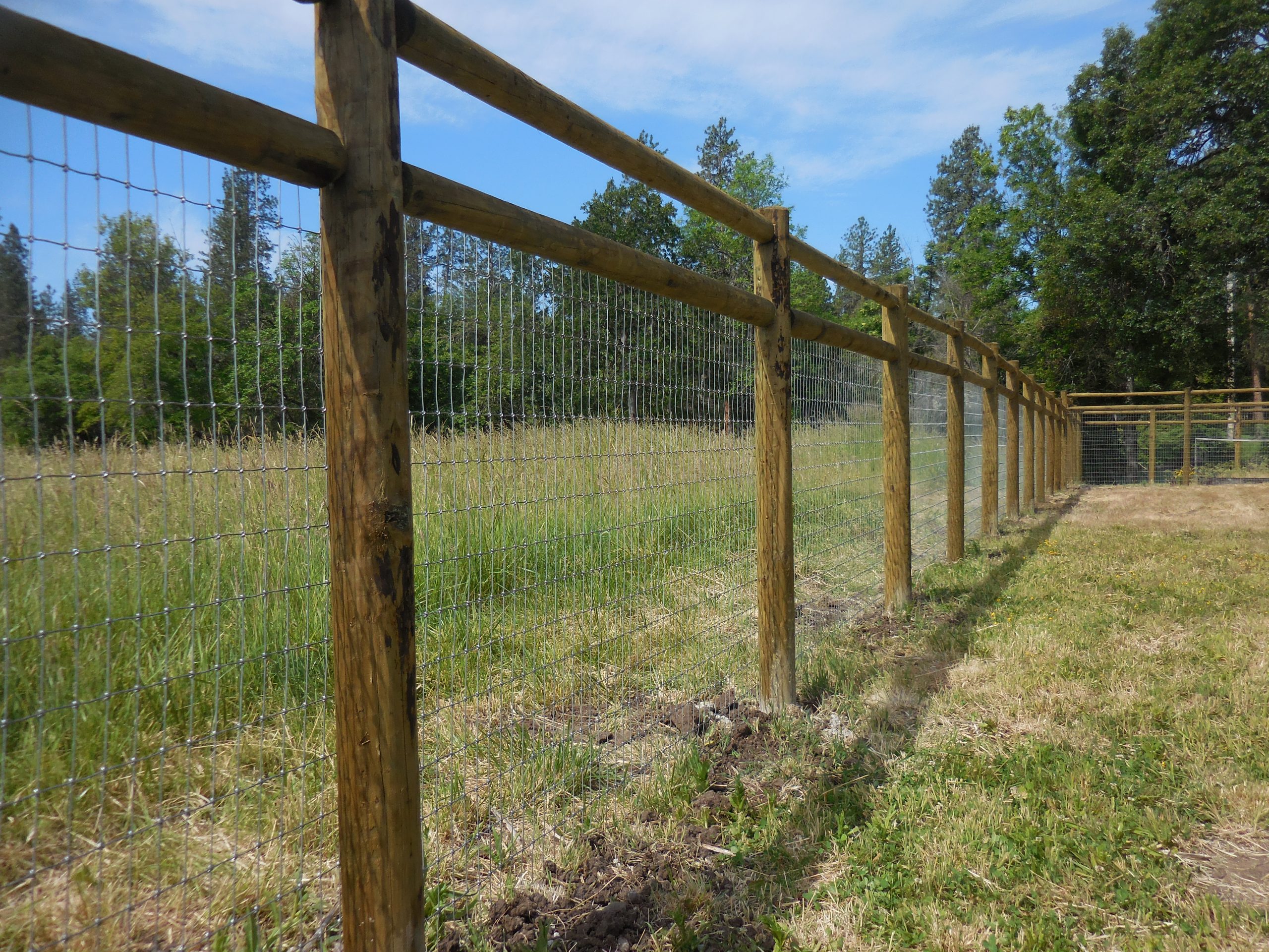 Post and rail fence with non-climb wire on a rural property in Jackson County, Oregon